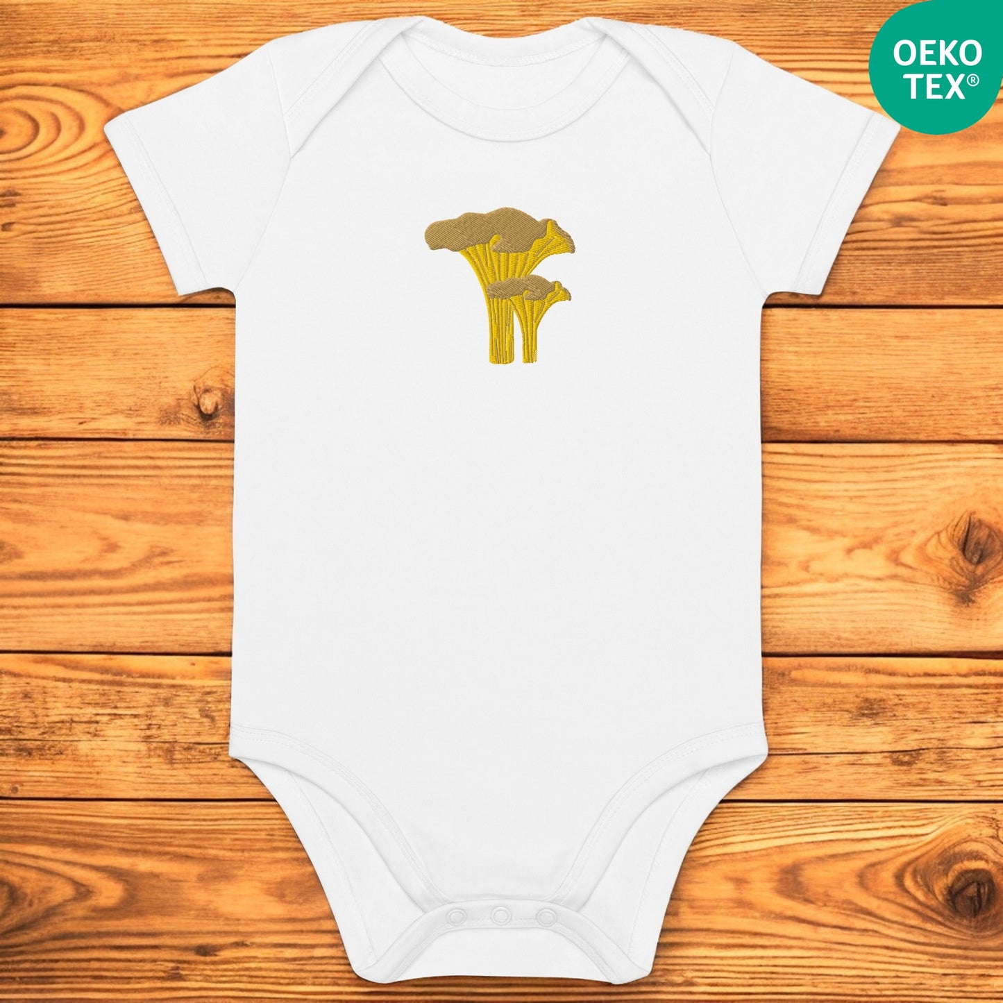 White baby body with a chanterelle on a wooden floor