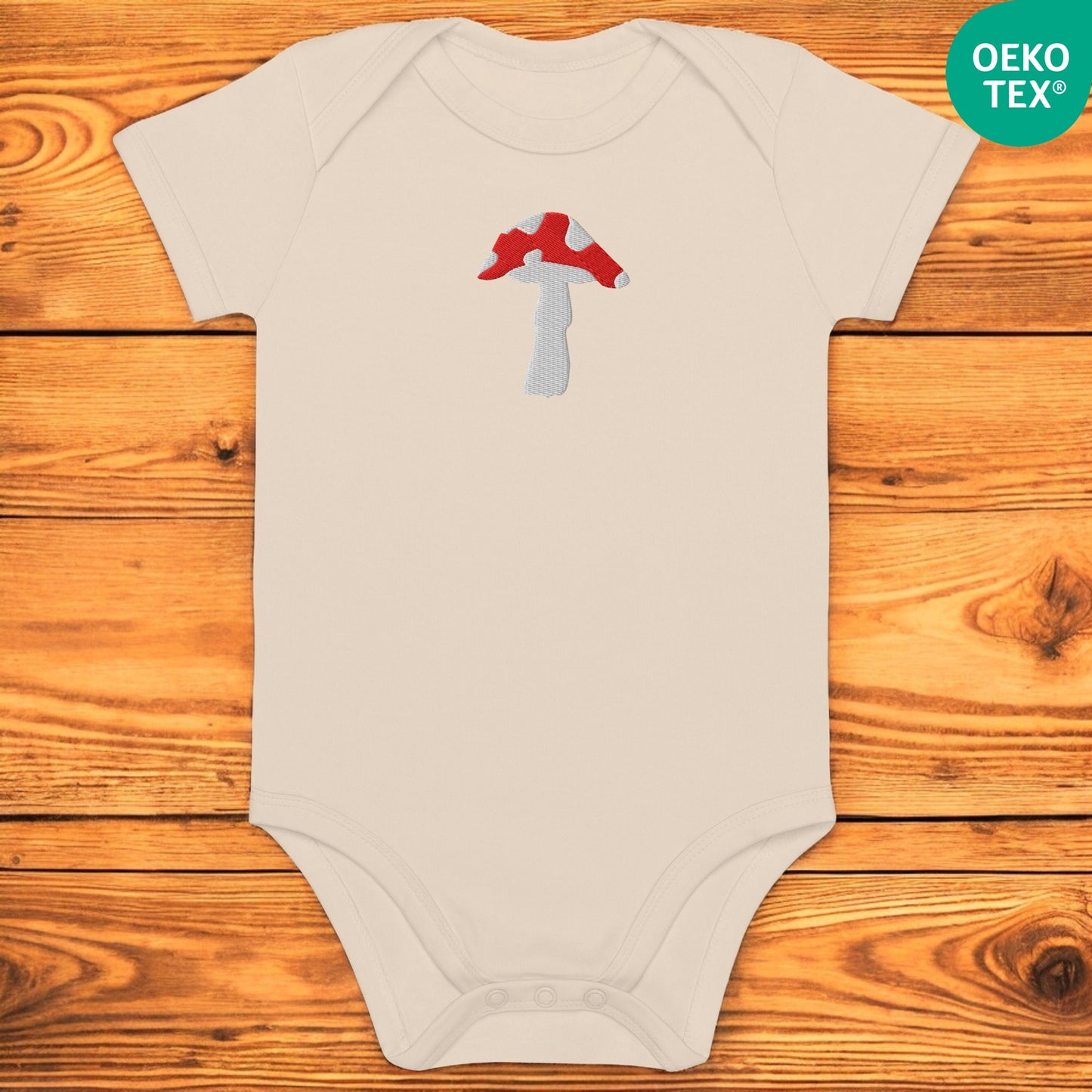 White baby body with fly agaric on a wooden floor