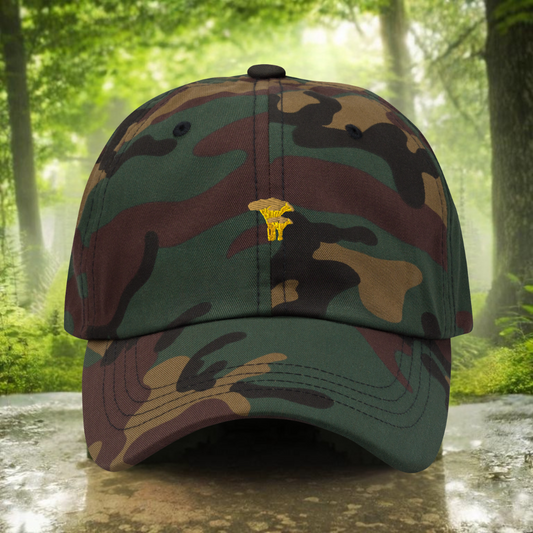 Front picture of a camouflage cap with a yellow chanterelle, in a forest background