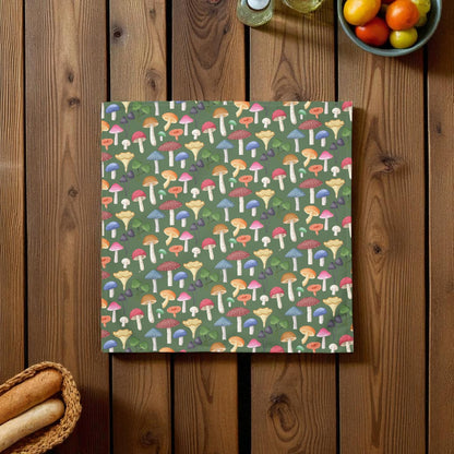 Colorful mushroom patterned towel on a wooden surface with bread and fruit in the background