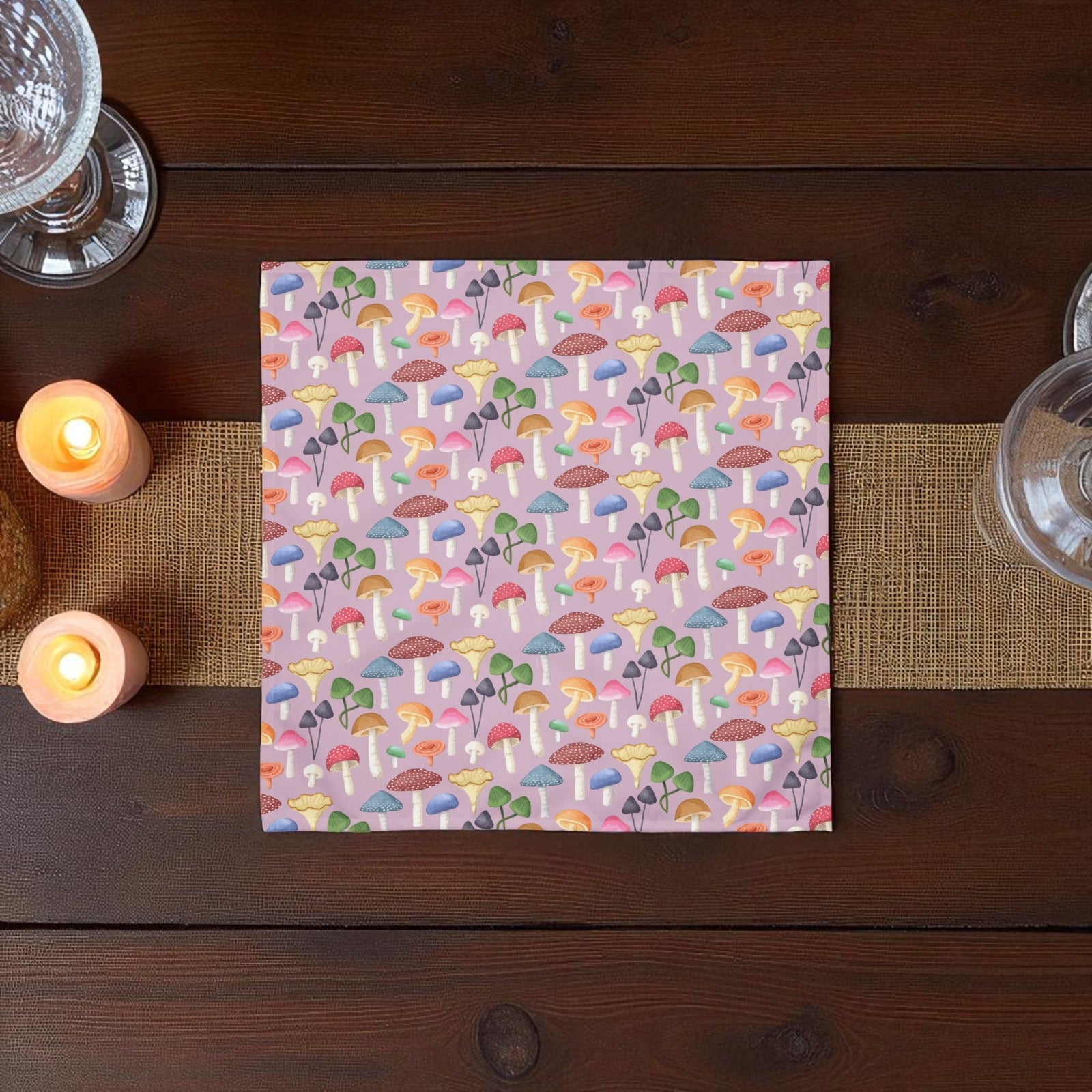 Colorful mushroom patterned paper on a wooden table with candles and glasses.