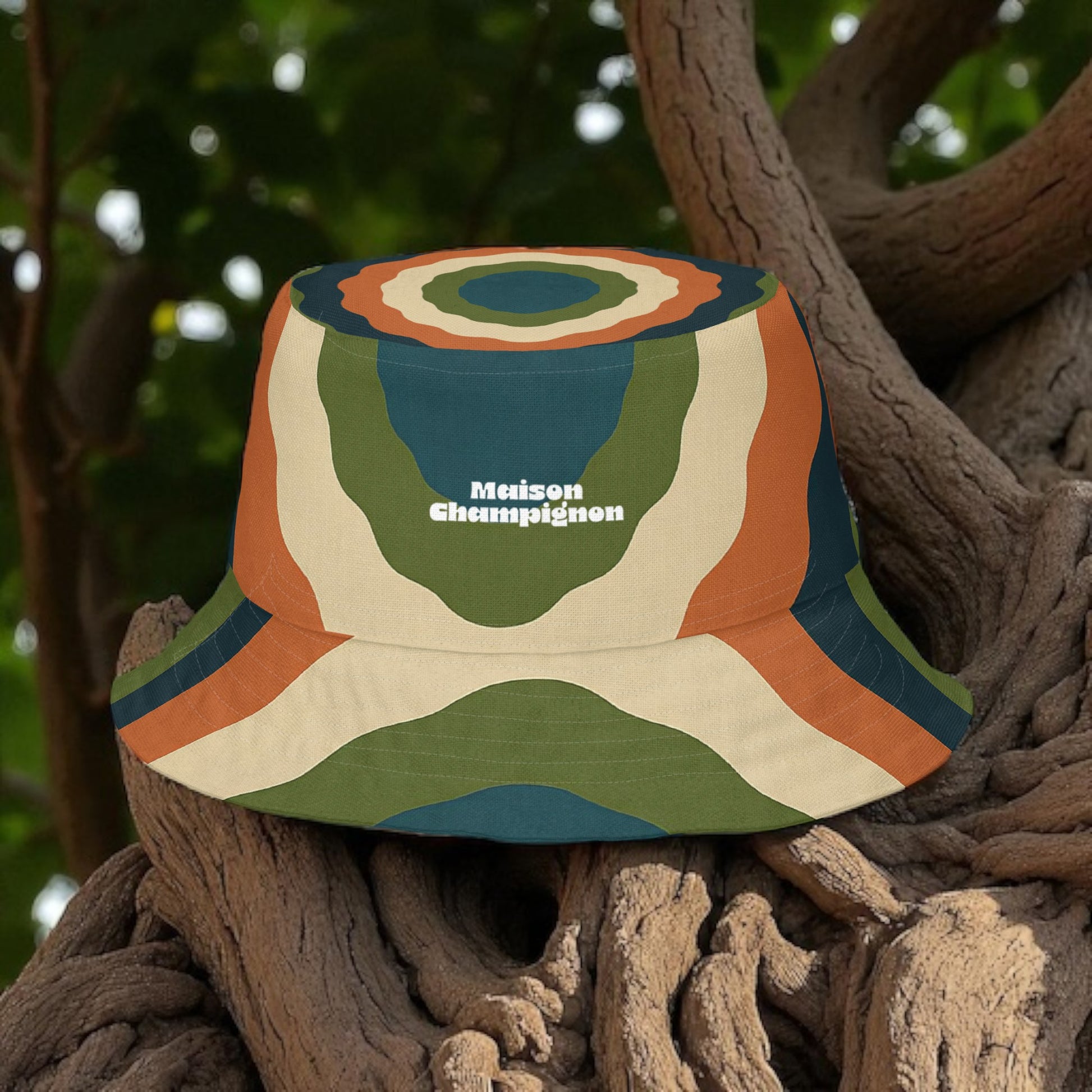 Colorful turkey tail bucket hat with 'Maison Champignon' branding on a tree