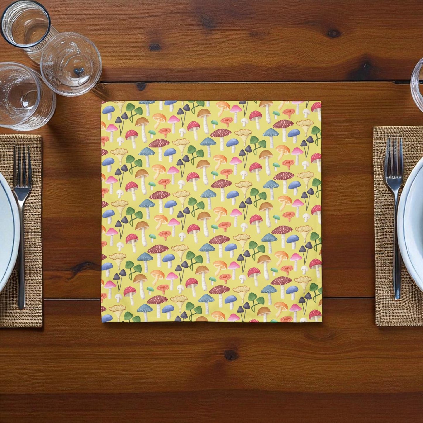 Yellow mushroom themed napkin laying on a wooden table between to plates and forks