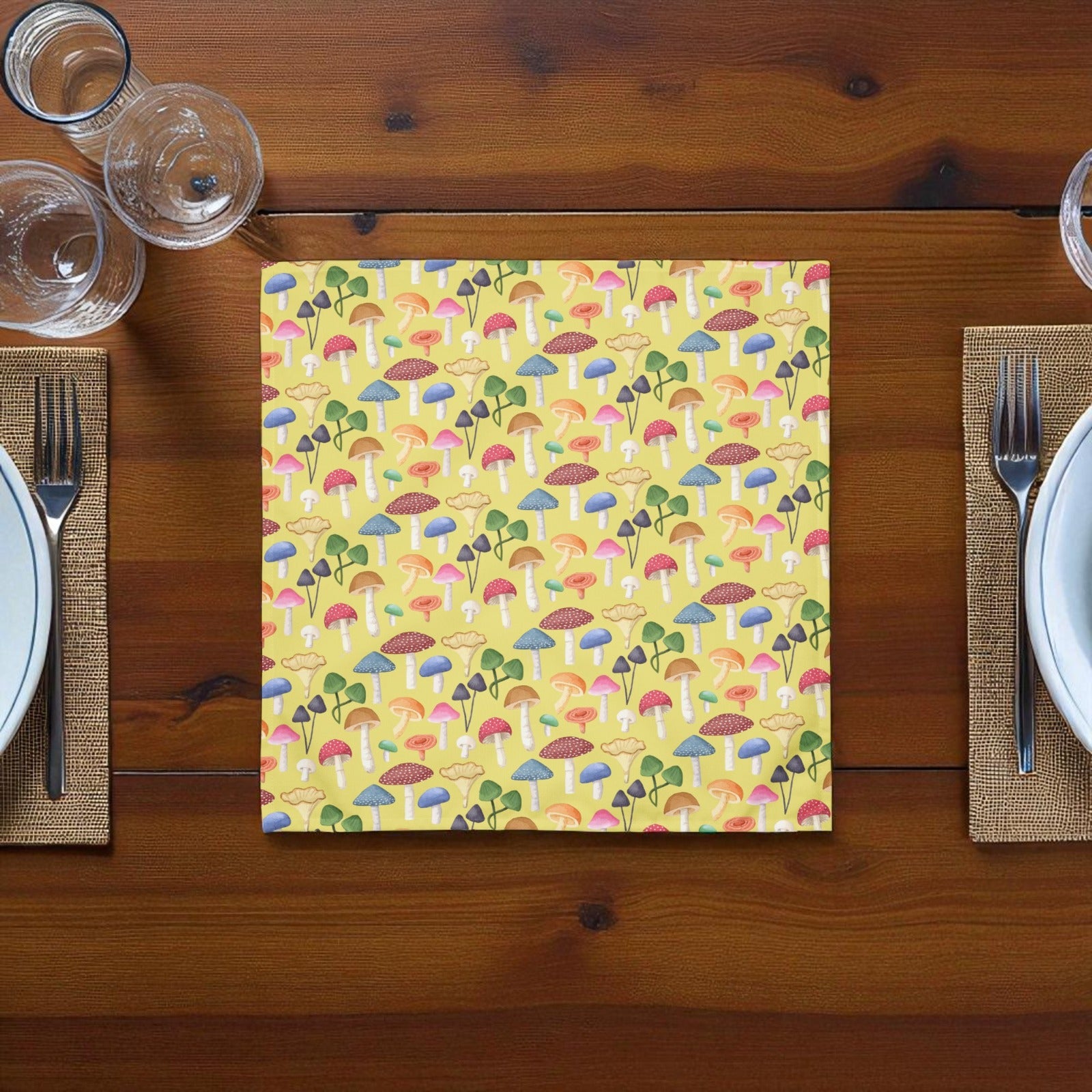 Yellow mushroom themed napkin laying on a wooden table between to plates and forks
